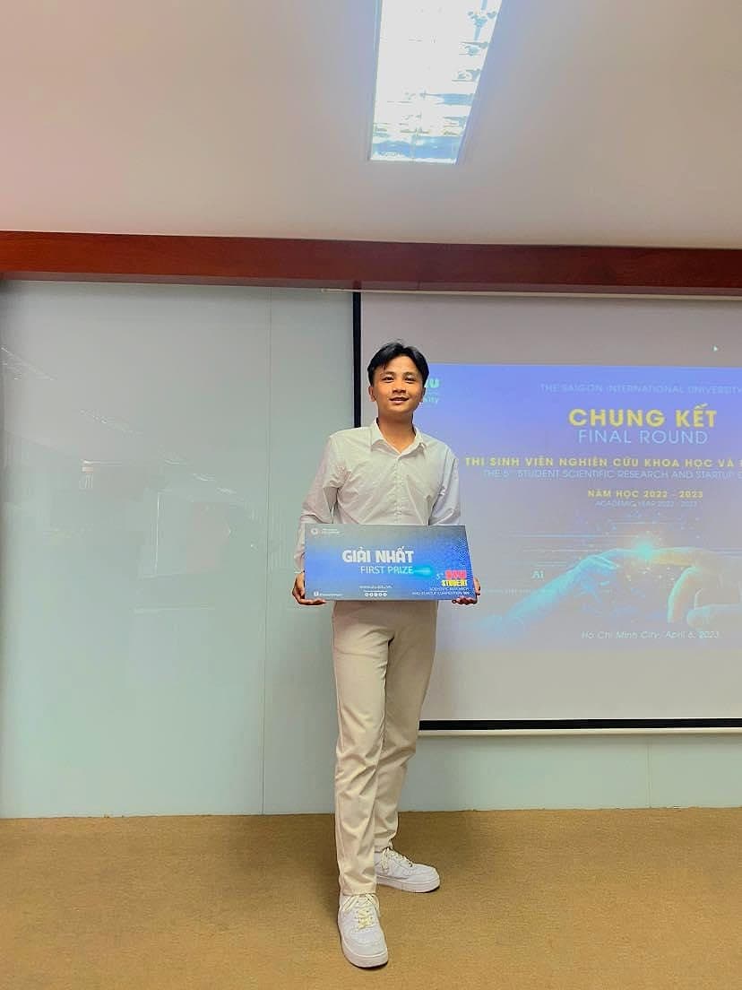 Phan Thanh Huy holding the First Prize board at the Startup SIU 2023 final round